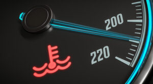 Car temperature gauge showing high engine temperature and red coolant warning light
