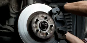 Mechanic installing a brake caliper onto a car brake disc