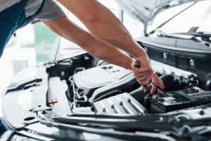 Mechanic using a wrench to work on a car engine