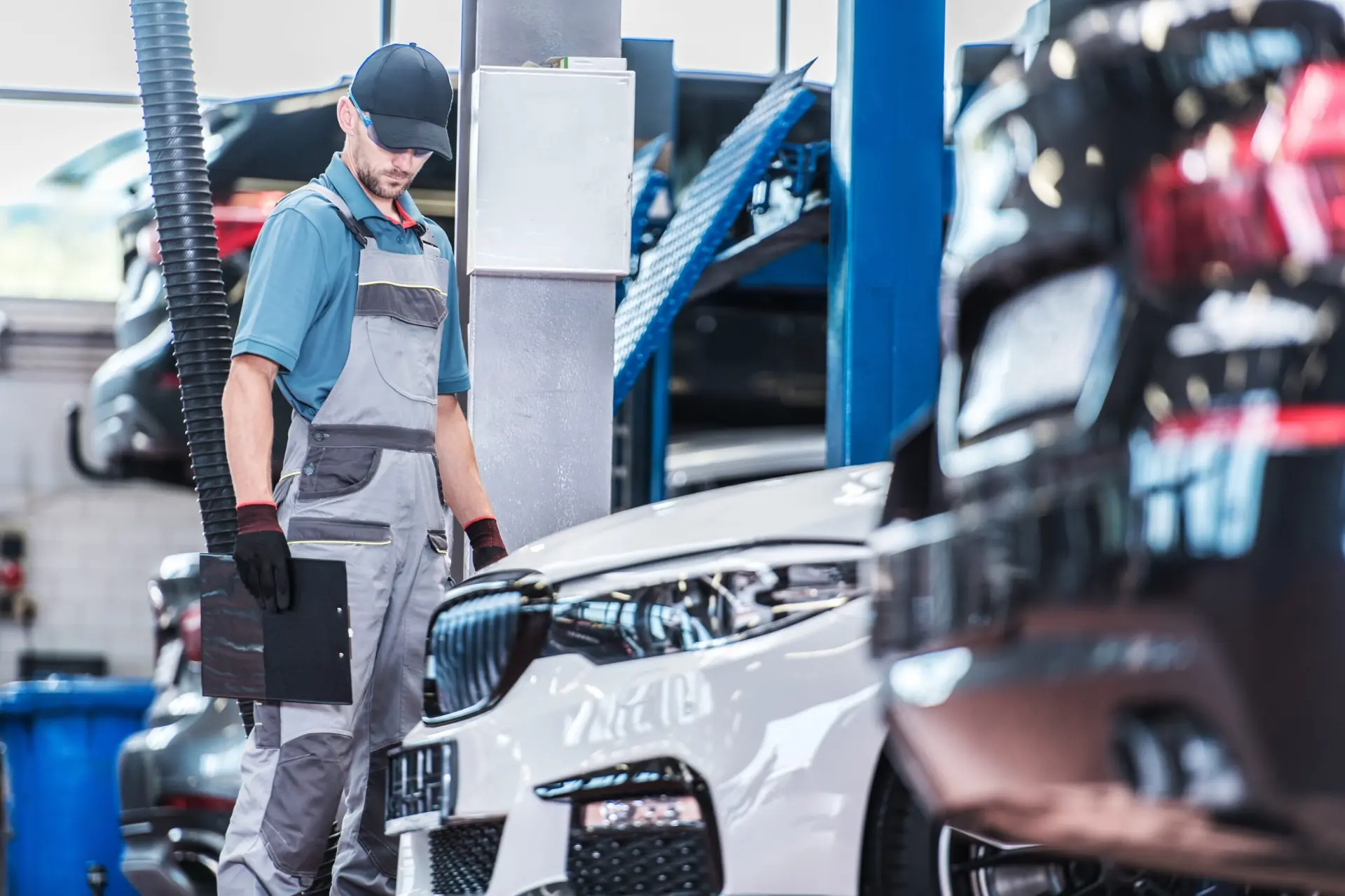 Mechanic inspecting a car with a clipboard in a repair shop